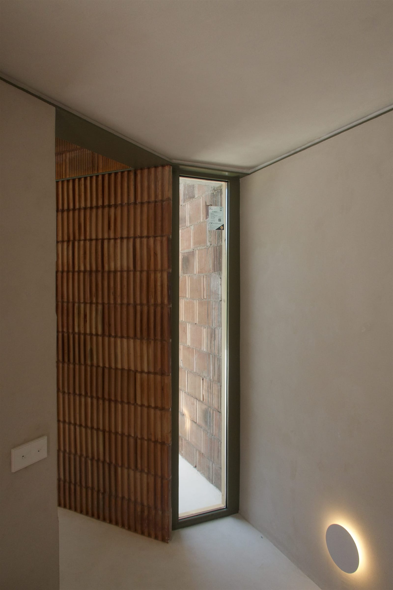 The slit window in the raw ceramic block wall — built